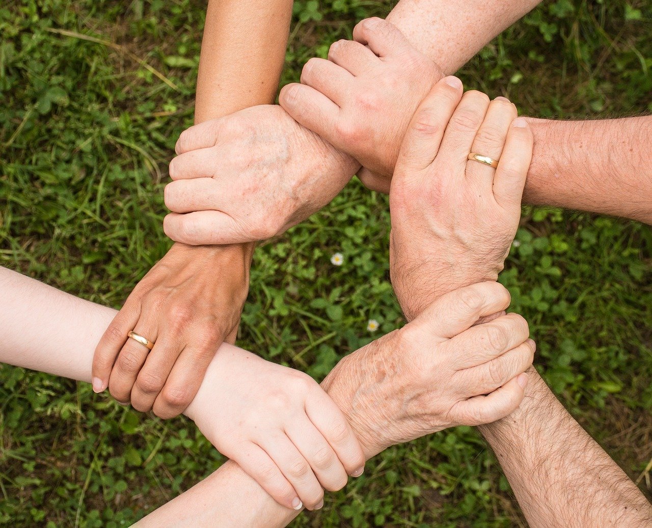 Grupo de pessoas orando juntas em círculo, simbolizando unidade e união espiritual