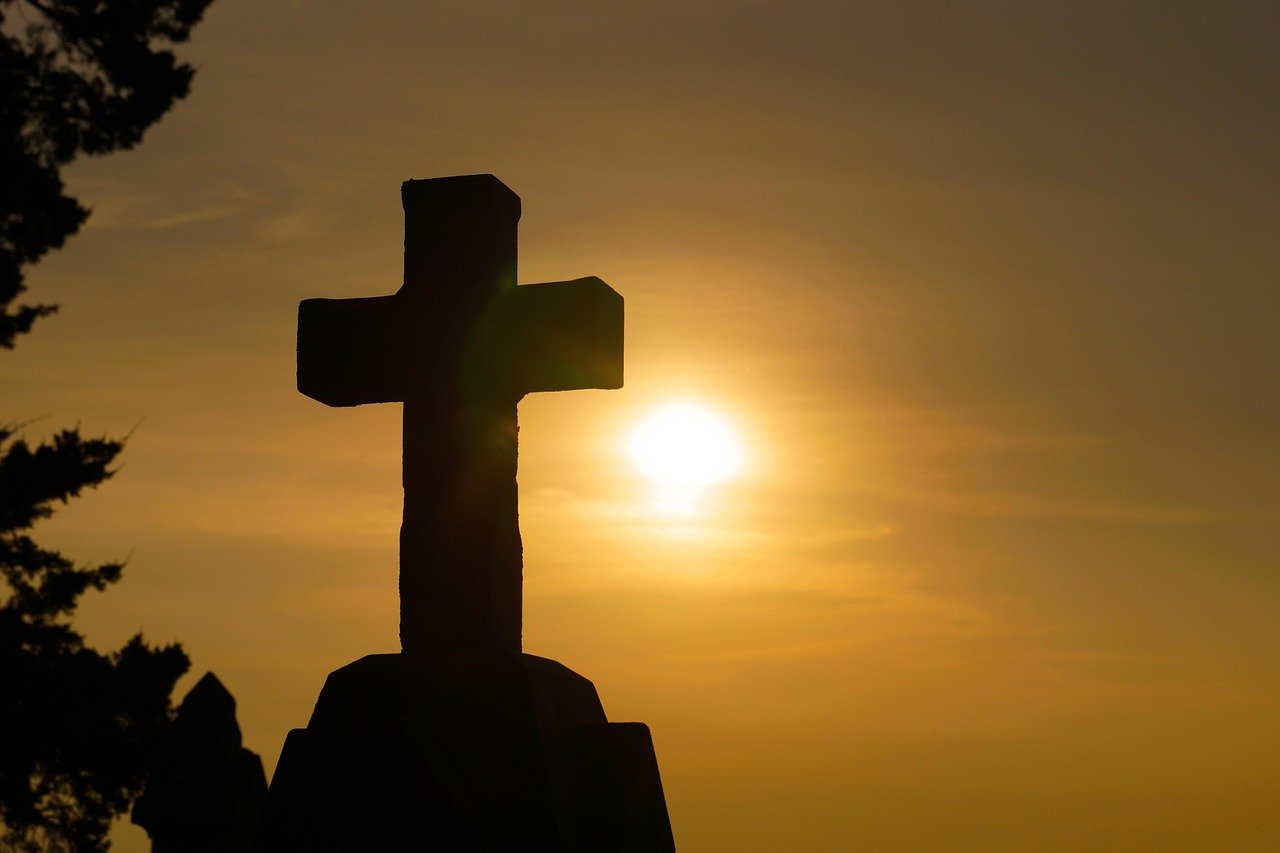 Mãos erguidas em consagração diante do nascer do sol