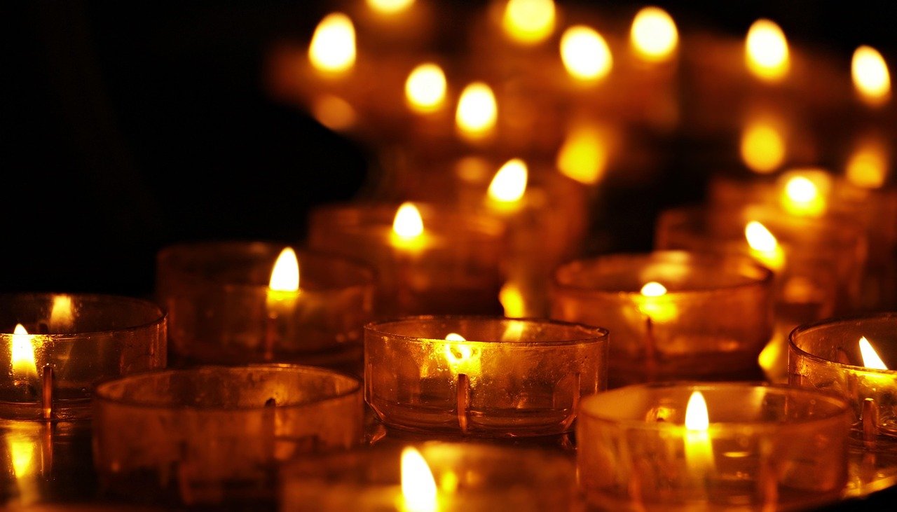 Irmãos reunidos em comunhão orando de mãos dadas em ambiente iluminado