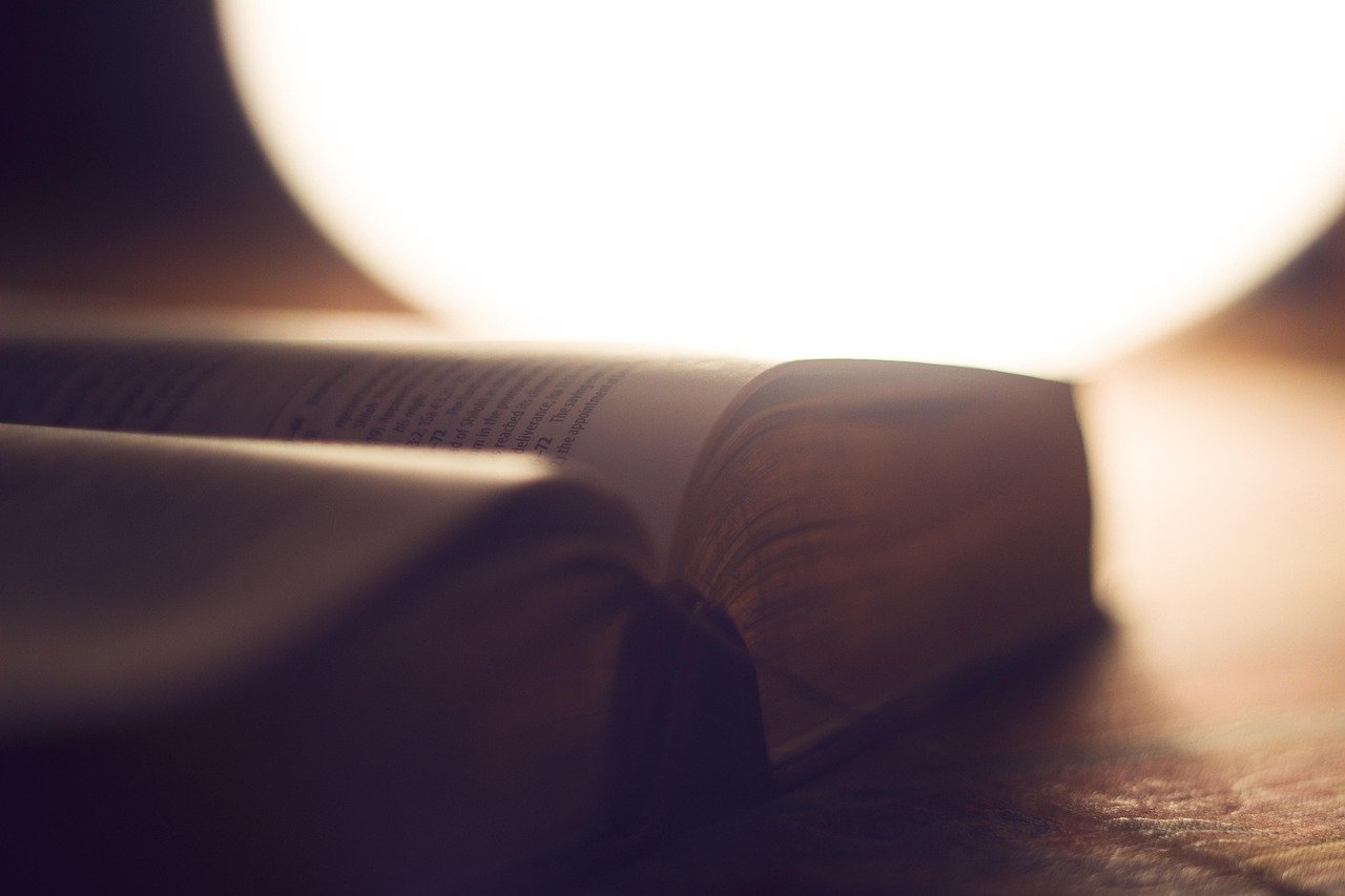 Bíblia Sagrada aberta sobre púlpito de madeira rústico com luz matinal
