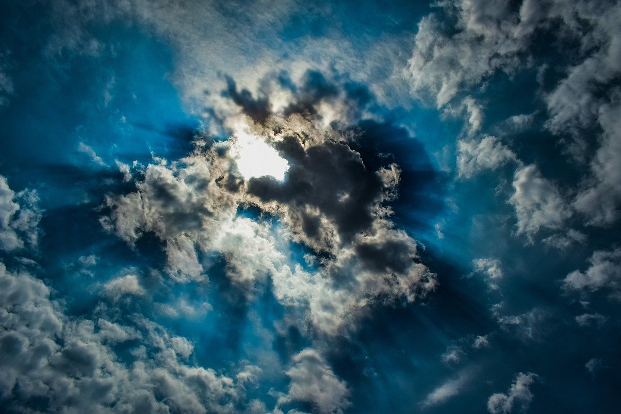 Céu aberto com sol resplandecente iluminando montanhas majestosas de glória