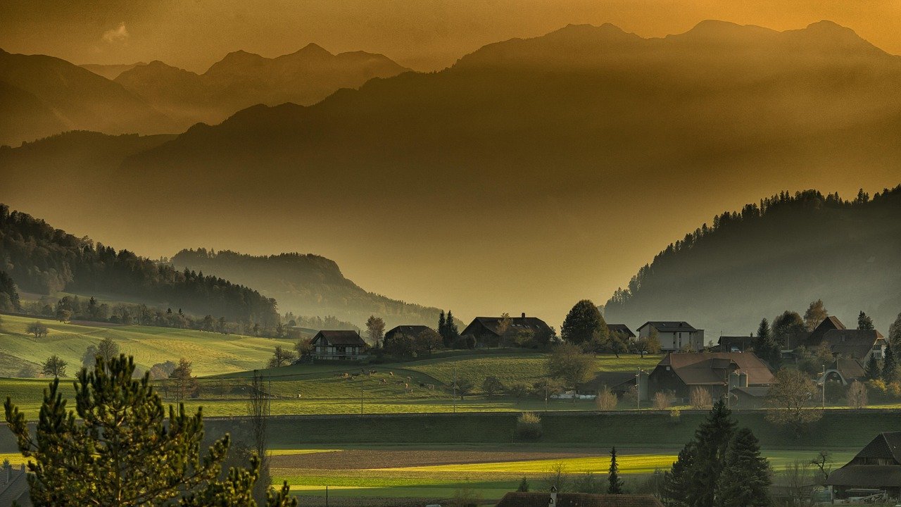 Montanhas serenas com árvores centenárias ao pôr do sol dourado em vale pacífico